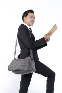 Side view of a young man against white background