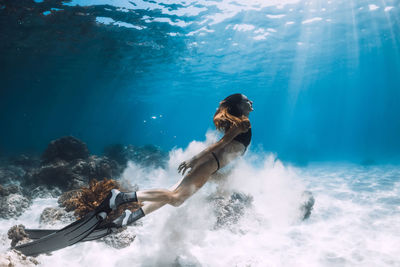 Rear view of woman swimming in sea