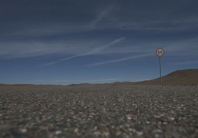 Surface level of pebble land against the sky