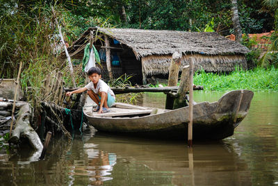 Woman in boat on lake against trees