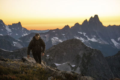 Backpacker uses headlamp to light his way after the sun sets.