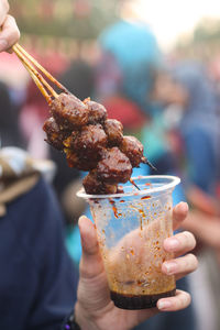 Cropped hands of woman holding food outdoors