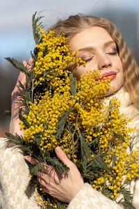 A  woman with a yellow acacia flowers. the concept of the spring - march 8, easter, women's day