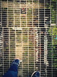 Low section of man standing on metal grate