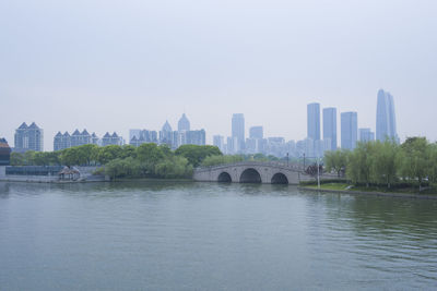 City at waterfront against clear sky