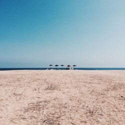 Scenic view of beach against clear blue sky