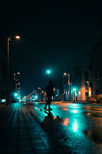 Man walking on illuminated street at night