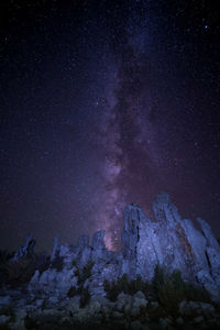 Low angle view of rock formation against sky at night