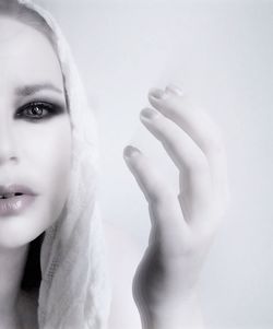 Close-up portrait of woman with eye make-up against white background