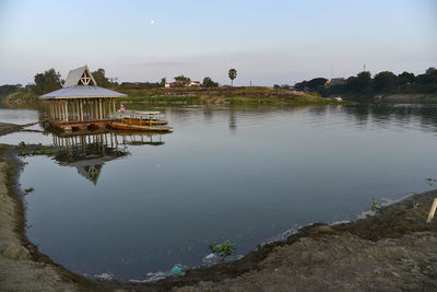 Scenic view of lake by building against sky