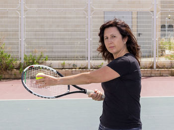 Portrait of woman playing tennis in court