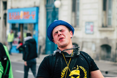 Portrait of man standing on street in city