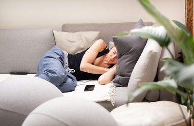 Midsection of man relaxing on sofa at home