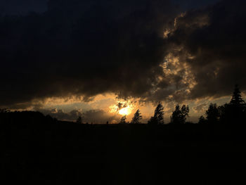 Silhouette of landscape against cloudy sky