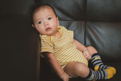 Portrait of cute baby girl sitting at home