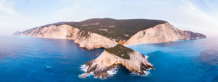 Scenic view of sea and mountains against sky