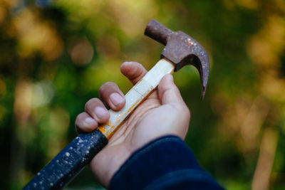 Cropped hand of man holding hammer