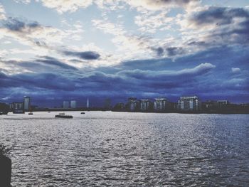 River in city against cloudy sky