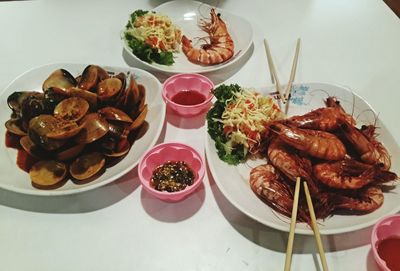 High angle view of seafood served in plates on table
