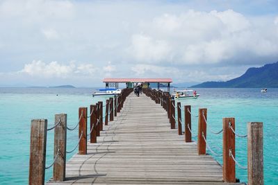 Wooden pier on sea against sky