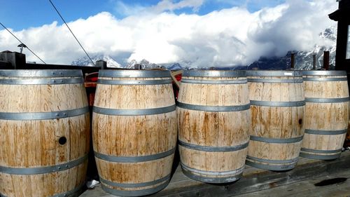 Close-up of wine casks against cloudy sky