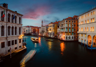 Venice grand canal at sunset with boat trails and illuminated historic buildings, long exposure