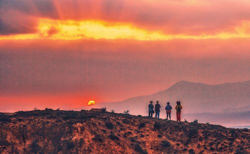 Silhouette of people walking on mountain