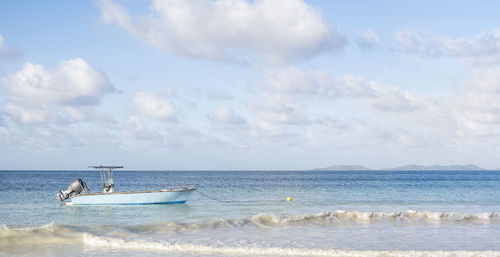 Old fashion fishing boat on ripped water and sky background