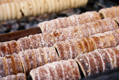 Process of baking trdelnik in prague, grilled rolled dough topped with sugar