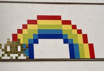 Close-up of multi colored flags against wall