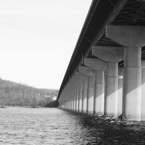 Low angle view of bridge over road against sky