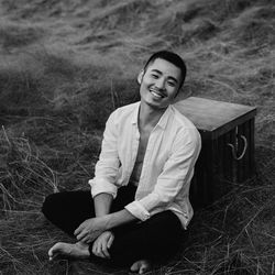 Portrait of smiling young man sitting outdoors
