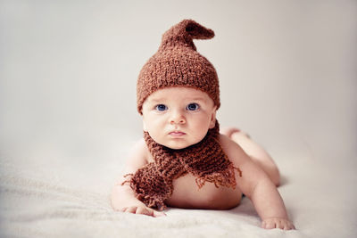 Portrait of cute baby girl lying on bed