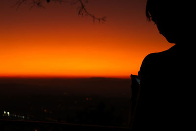 Silhouette man against orange sky
