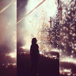 Silhouette of man against illuminated window