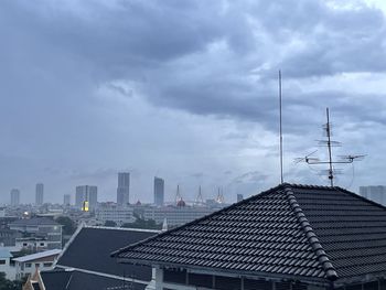 Buildings in city against cloudy sky