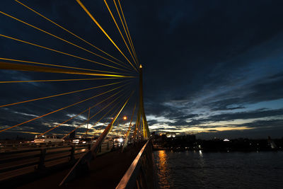 View of suspension bridge over river at night