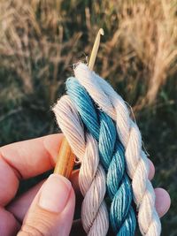 Cropped hand of person holding rope