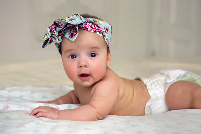 Baby girl lying on the bed in a diaper