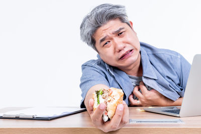 Young man using mobile phone while sitting on table