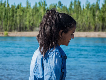 Side view of young woman looking at lake