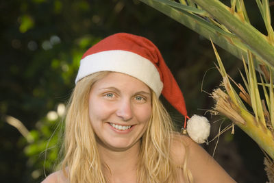 Portrait of smiling woman wearing santa hat at night