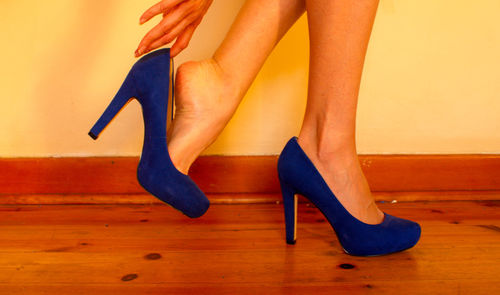 Low section of woman wearing high heels at home