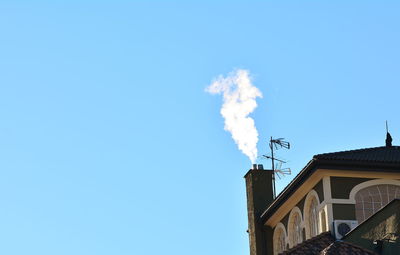 Low angle view of smoke emitting from chimney against sky