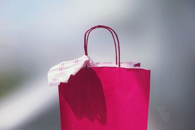 Close-up view of pink shopping bag against gray background