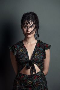 Portrait of teenage girl standing against wall