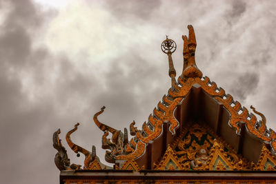 Low angle view of statue against temple building against sky