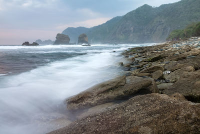 Scenic view of sea and mountains against sky