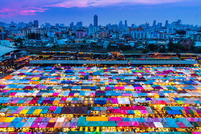 Illuminated market in city at dusk