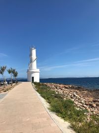 Lighthouse by sea against sky